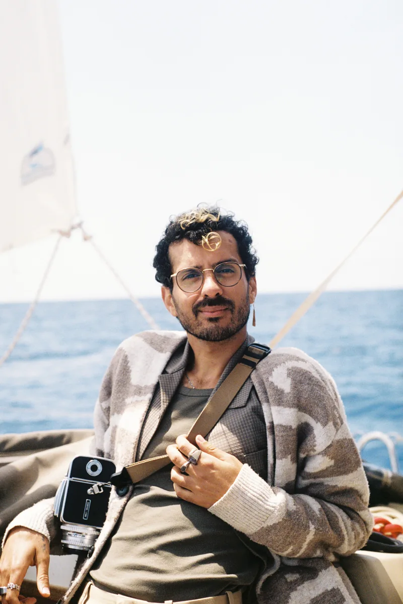 Karam on a sailboat with his film camera